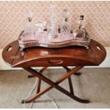 A mahogany butler’s tray, with pierced handles, on folding X frame support.