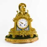 A 19th century gilt-metal and porcelain inset mantel clock, the circular enamel dial with Roman