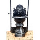 Garden Statuary: A cast iron fountain, painted black, cast with a lion head spout.
