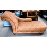 A modern chaise longue, in red and cream patterned upholstery, raised on mahogany turned legs.