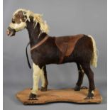 An antique child's play horse / pulley horse, clad in pony skin, leather saddle and glass eyes,