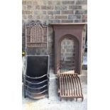 An antique cast iron fire surround together with a pair of wrought iron folding seats and a fire