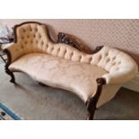 A Victorian walnut chaise longue, of shaped outline with pierced carved scroll work, with button