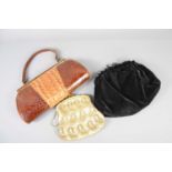 A vintage crocodile skin handbag together with a vintage beaded bag and a velvet evening bag.