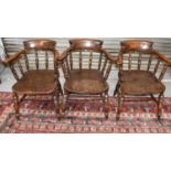 A group of three antique elm Captain's chairs.