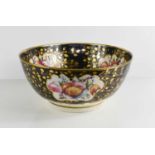 A 19th century black ground bowl, painted with floral cartouches, and highlighted with gilding, 30cm
