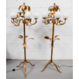 A pair of 20th century gilt-metal floor lamps, with leaf decoration and spherical glass shades, on