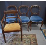 A set of three 19th century dining chairs with carved balloon backs and blue velvet upholstered