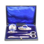 A cased silver manicure set, complete with scissors, nail file and buff, nail cleaner and a small