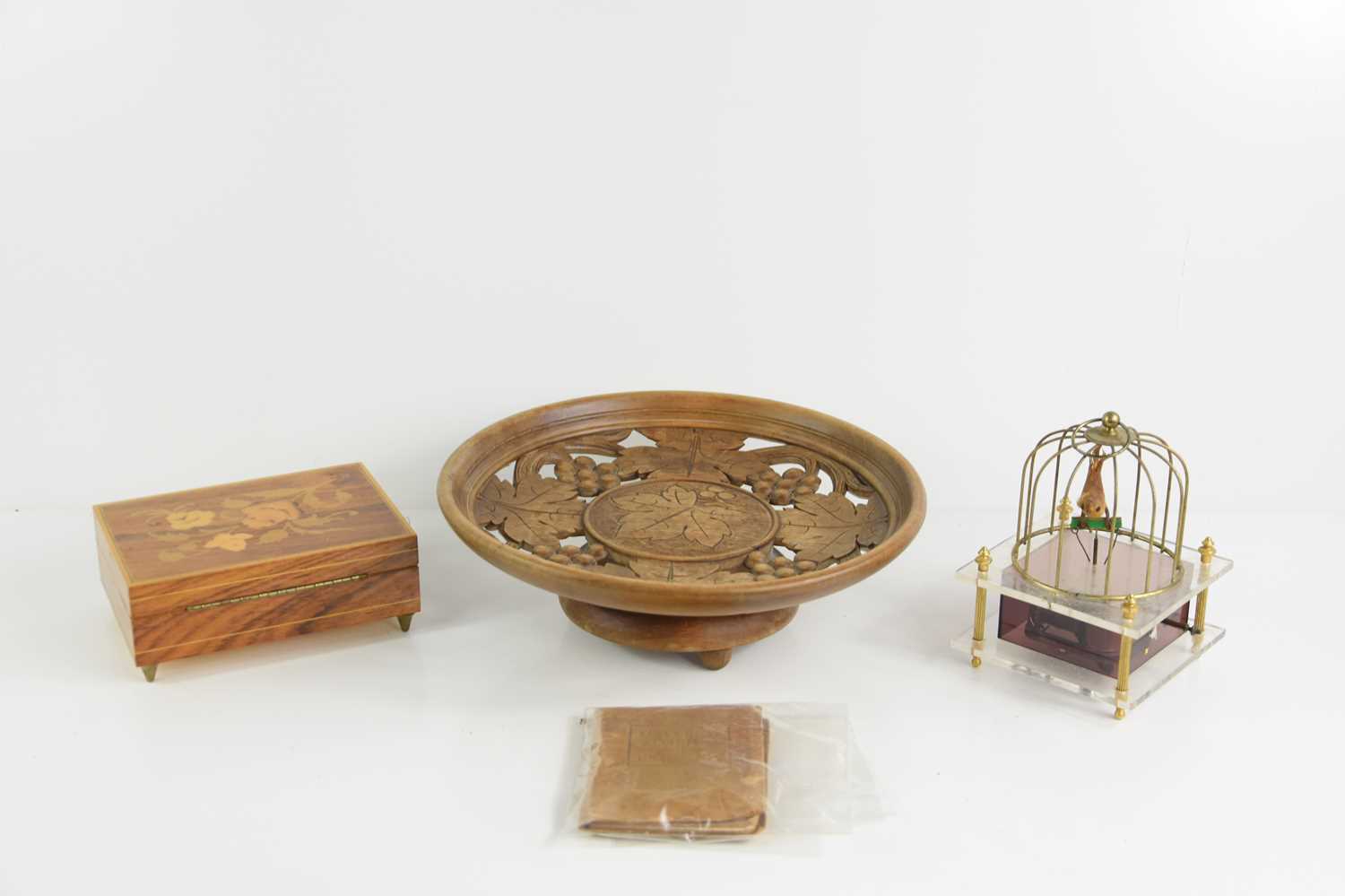 A vintage Sankyo musical bird in a cage together with a wooden musical dish, a musical box and a