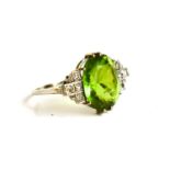 A white gold Art Deco peridot or possibly green garnet and diamond dress ring, size Q, the oval