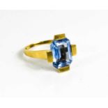 A 14ct gold and blue topaz dress ring, with emerald cut stone, in modernist setting, size P, 5.1g.