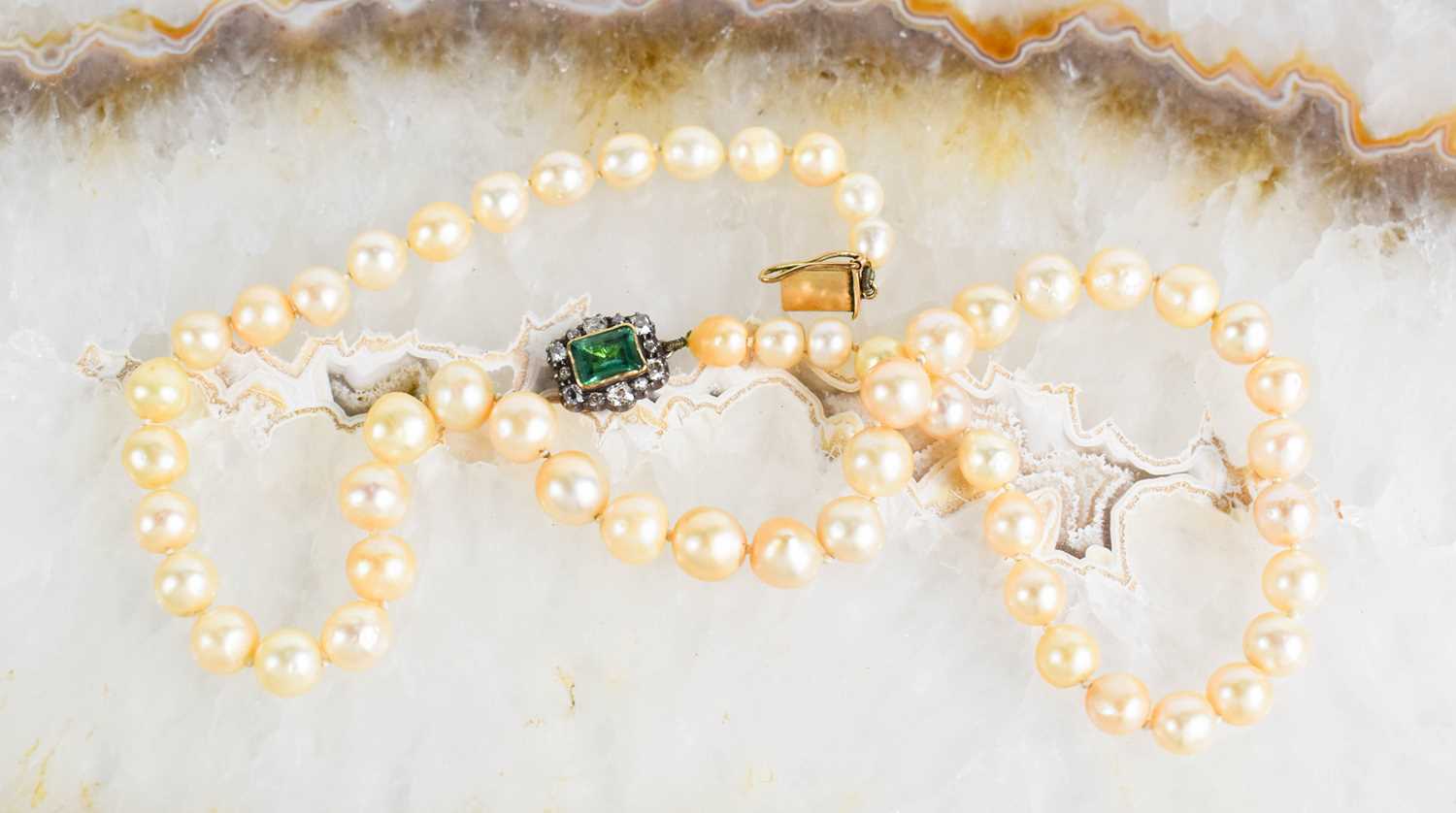 A Georgian pearl necklace, with a gold (tested as 14ct) clasp set with a central emerald bordered by