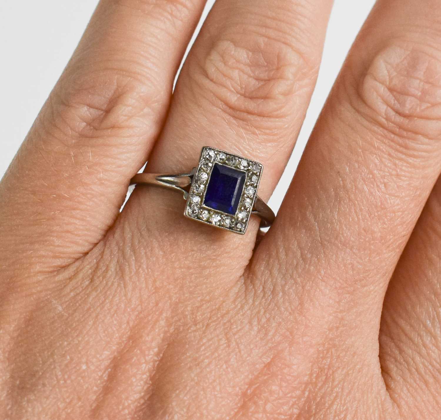 A white metal, diamond and sapphire ring, the rectangular cut sapphire bordered by chip diamonds, - Bild 2 aus 2