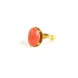 A 9ct gold [tested as] and coral cabochon ring, size N, 3.9g.