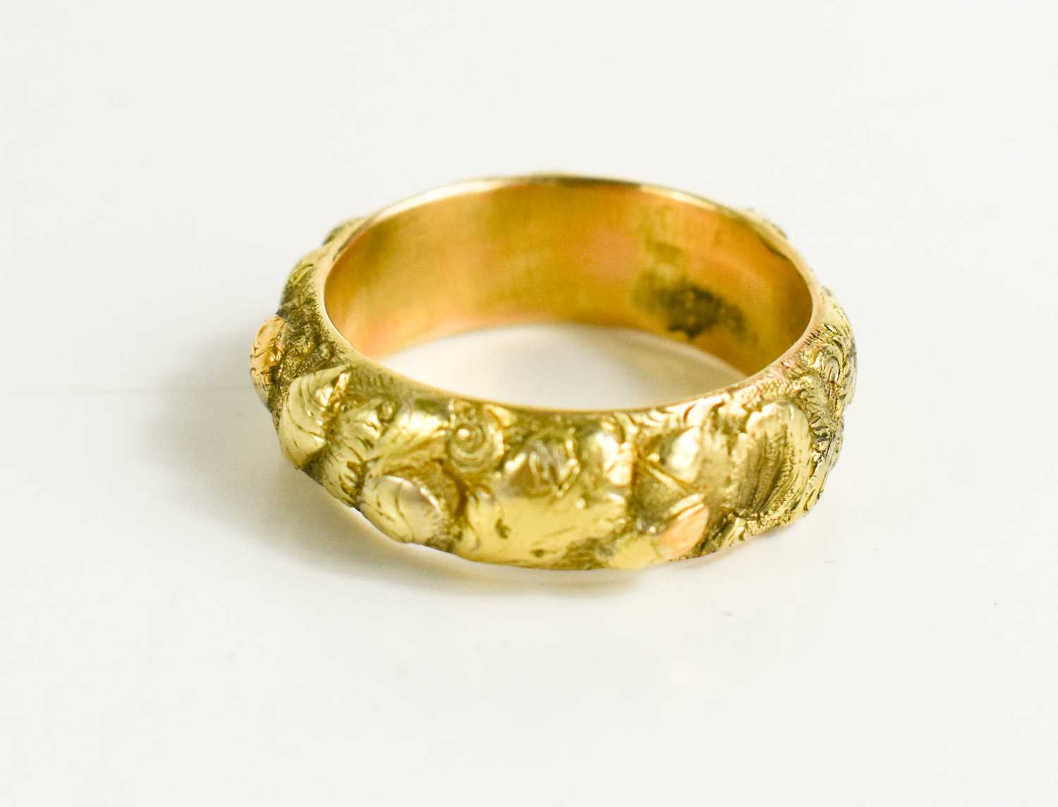 A gold ring, with rose gold and silver highlights, relief moulded flower and acorn design