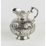A continental silver jug, embossed with putti in various poses, raised on a footed base, and