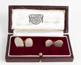 A pair of 18ct yellow and white gold cufflinks, of oval form, with machine engraved decoration, in