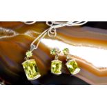 A silver and peridot set demi parure of pendant on chain and earrings.