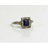 A white metal, diamond and sapphire ring, the rectangular cut sapphire bordered by chip diamonds,