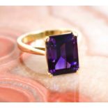 A 9ct gold and amethyst cocktail ring, the emerald cut amethyst in four claw setting, size N, 3.6g.