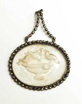A late Georgian marcasite and pressed glass pendant, depicting birds watering at an urn, with an