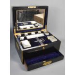 A Victorian ebonised vanity case, with brass carrying handles, fitted with ten silver lidded glass