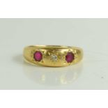 An 18ct gold, ruby and diamond three stone ring, each stone in a starburst setting, central