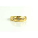 An 18ct gold and diamond three stone ring, each diamond in a starburst setting, largest central