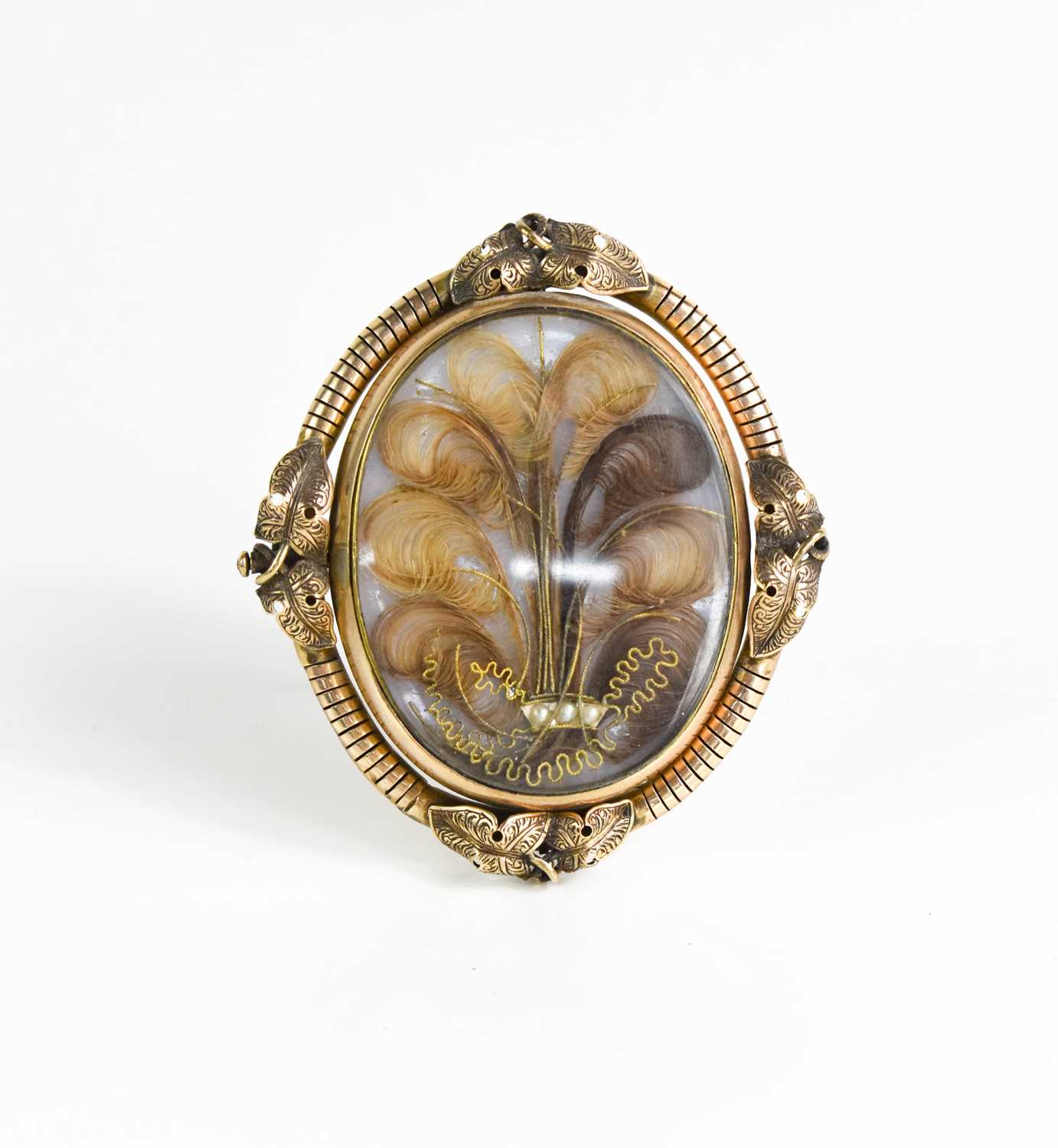 A Victorian pinchbeck mourning brooch on stand, of oval form, inset with lockets of hair woven