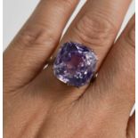 A white metal (likely platinum) and pale lilac sapphire ring, the cushion cut lilac coloured