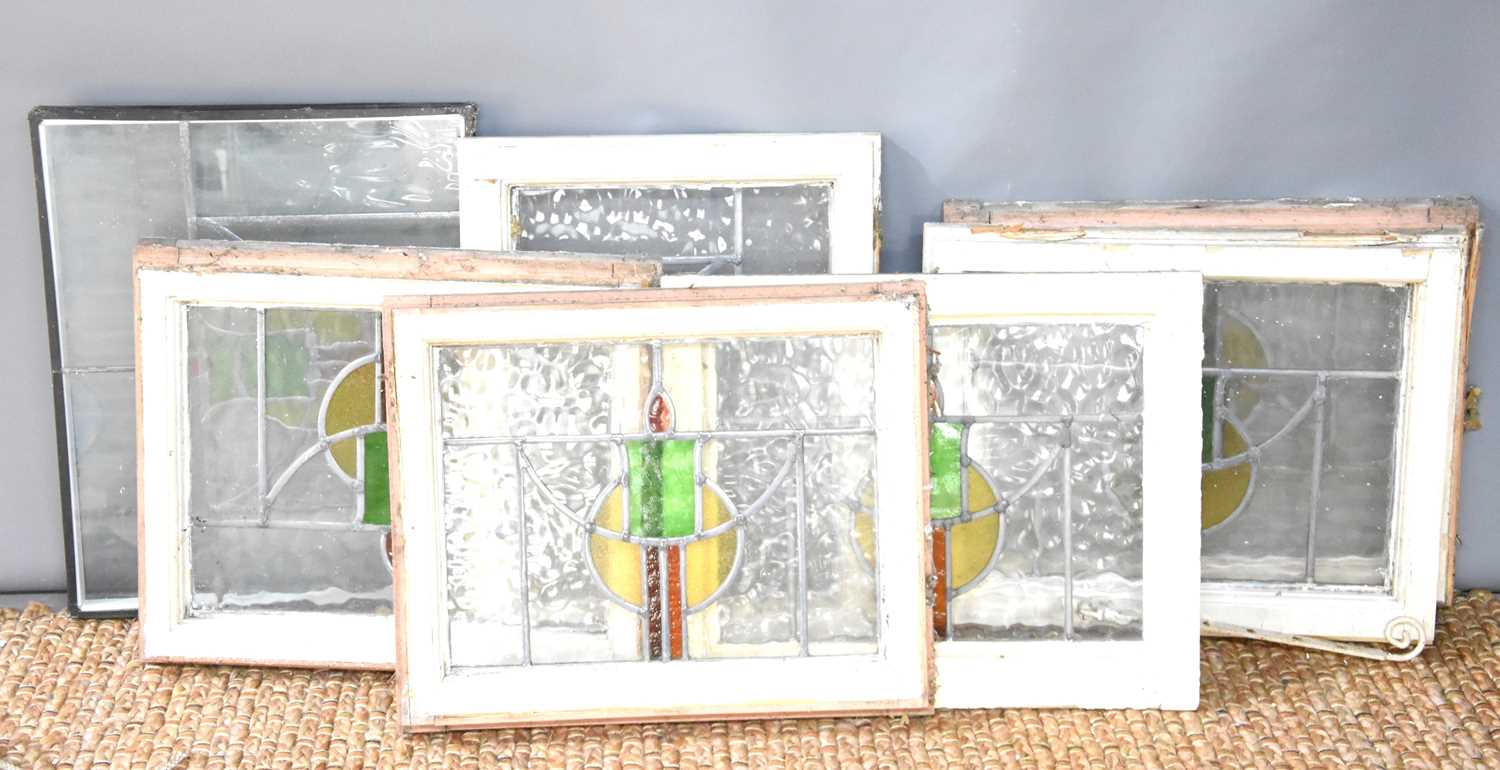 A group of seven Art Deco stained glass windows, six are in their original wooden frames, 42cm by