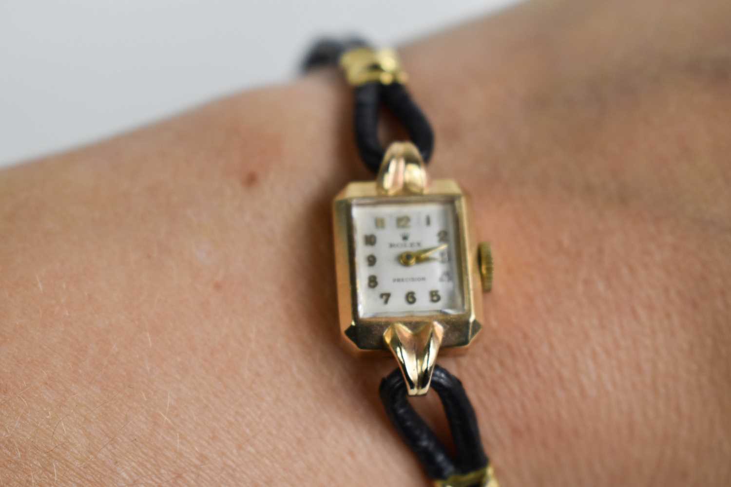 A 9ct gold ladies Rolex wristwatch, circa 1920, with a black leather strap.