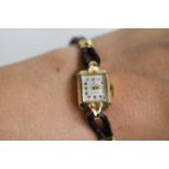 A 9ct gold ladies Rolex wristwatch, circa 1920, with a black leather strap.