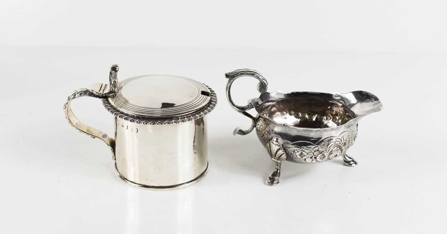 An early George III silver cream jug, with acanthus scroll handle, the flared cauldron body,