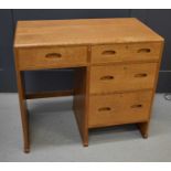 A small Heals oak desk, composed of a bank of four short drawers, 76 by 83 by 45cm, knee space