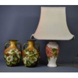 A Moorcroft lamp base, together with a pair of Doulton Lambeth twin handled vases, signed with