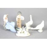 A group of Lladro figurines to include a boy with football, girl beside bird, two geese and a