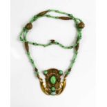 An Art Noveau style jade and gold coloured metal pendant necklace.