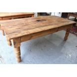 A antique pine kitchen / dining table with seven plank top above large turned legs, 76cm by 214cm by