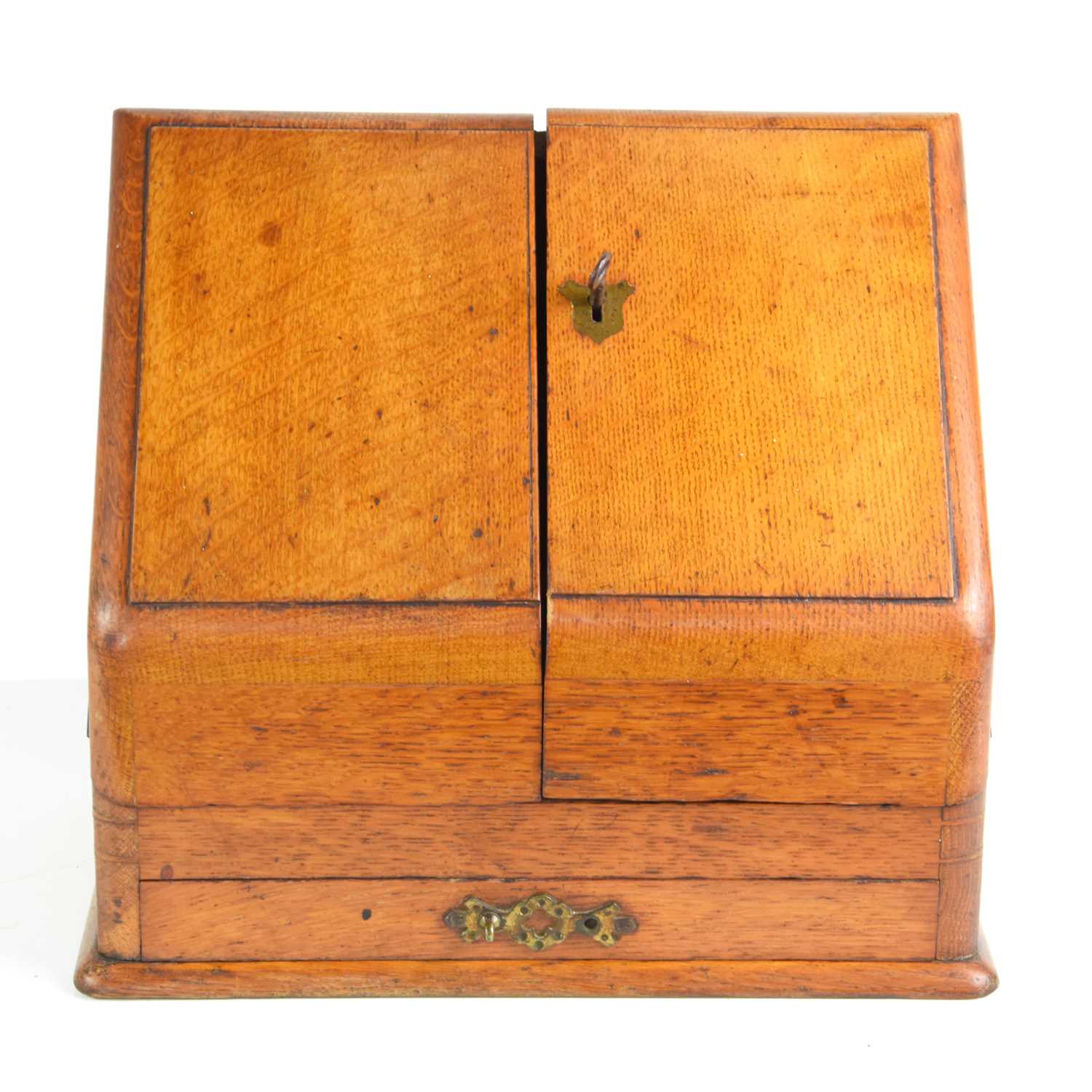 An early 20th century two door oak stationery box, fitted interior and single drawer below, 26.5cm