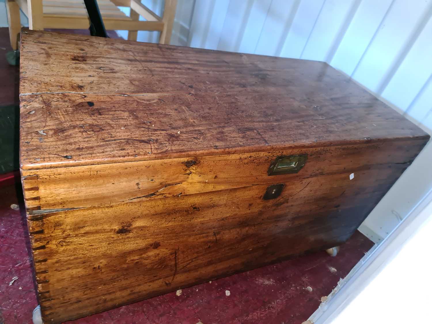 A 19th century pine chest, with iron handles and raised on castors.