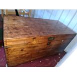 A 19th century pine chest, with iron handles and raised on castors.