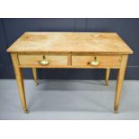 An antique pine two drawer side table, with brass cup handles.