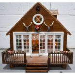 A Swiss cottage or chalet doll's house, complete with electrics and dolls, furniture and