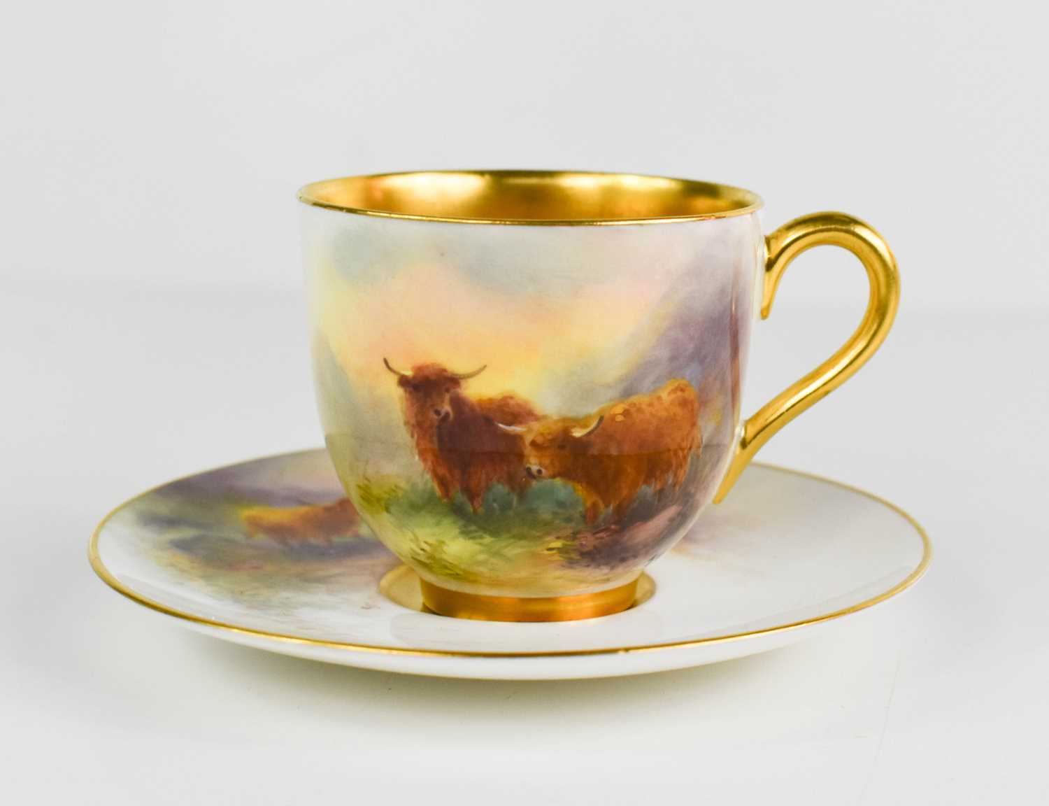 A Royal Worcester cup & saucer, by Harry Stinton, painted with Highland cattle with gilded interior,