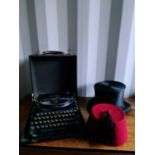 A vintage Remington typewriter together with a ladies riding hat and a Fez.