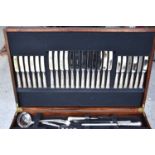 A mahogany canteen table of cutlery for twelve settings.