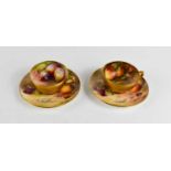 A pair of Royal Worcester miniature cups and saucers, painted with fruits to mossy ground, puce mark
