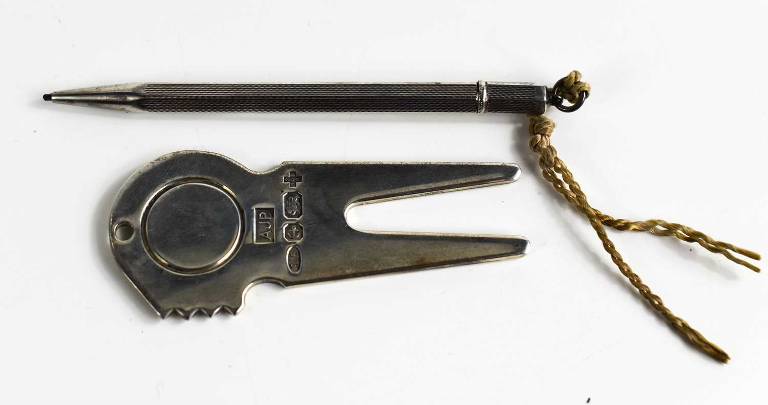 A silver golfing pitch repairer and ball marker, together with a silver propelling pencil circa